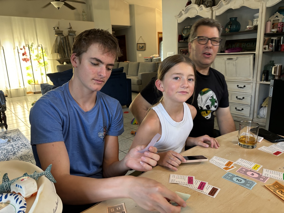 Jackson playing a card game at the table with family