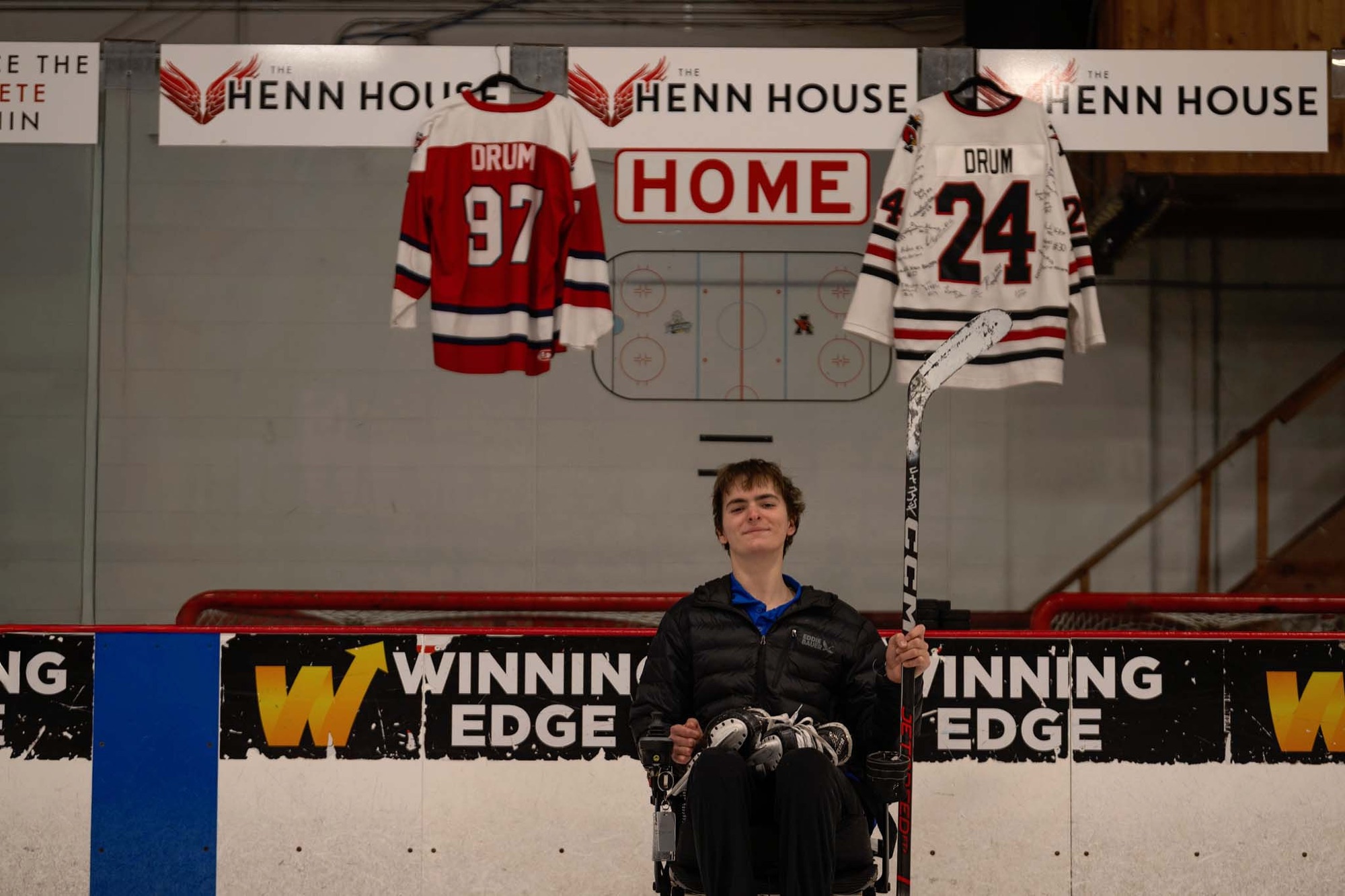 Jackson at the rink with his number 97 and number 24 jerseys hanging behind him