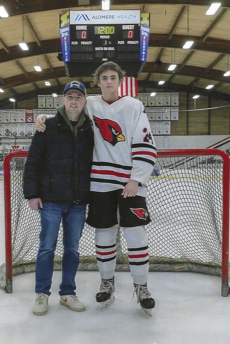 Jackson in his Alexandria Cardinals jersey with his dad, Jason